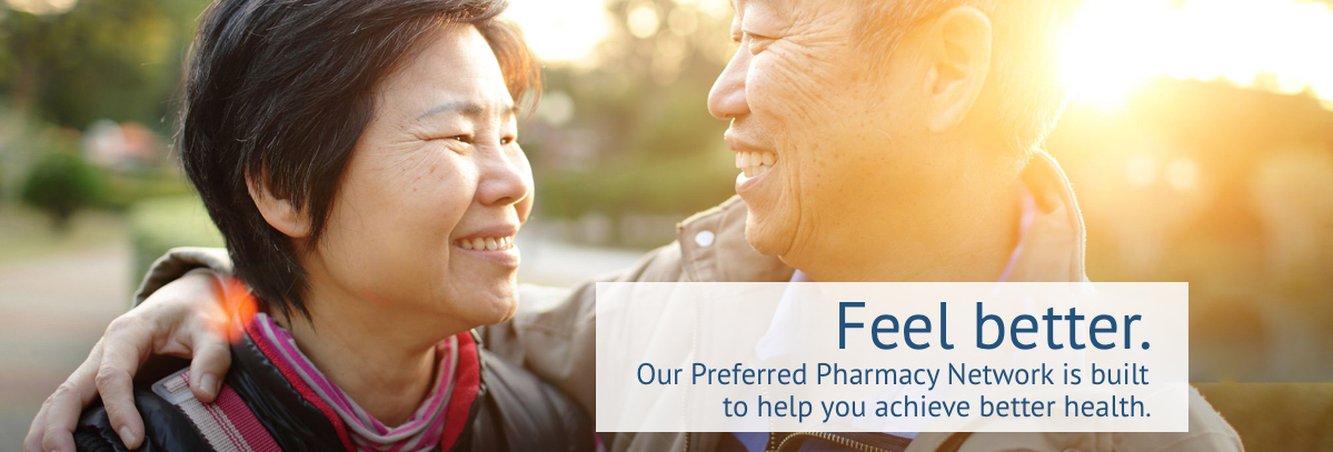 Older Asian couple smiling at each other after discussing Sun Life Preferred Pharmacy Network